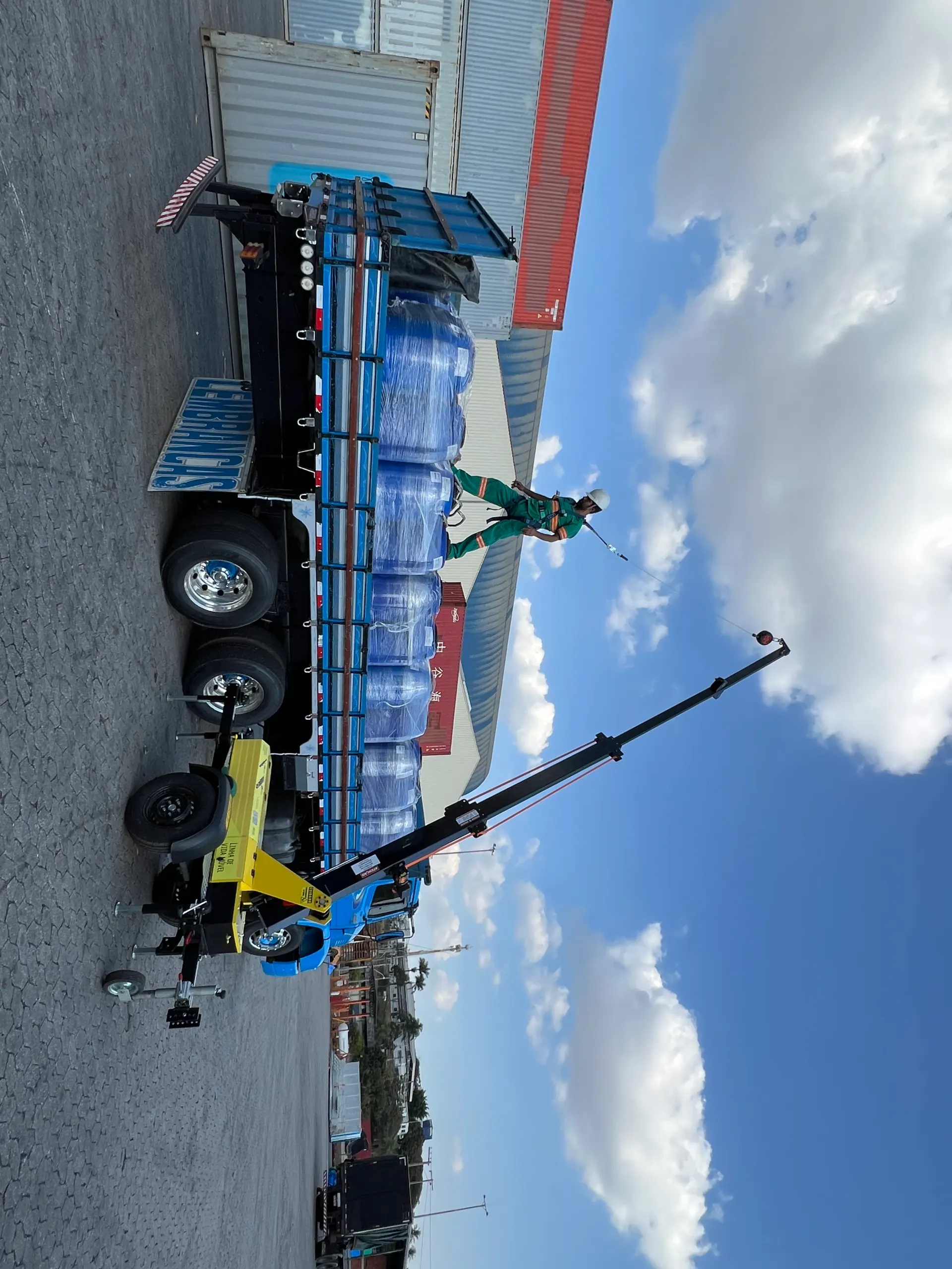 Operador em cima de carreta carregada com AMX linha de vida móvel posicionado ao lado